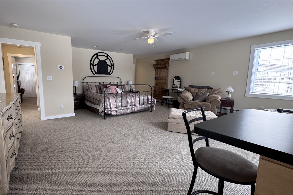 Primary bedroom with private wet bar, large stand-alone soaking tub, and access to private balcony 
