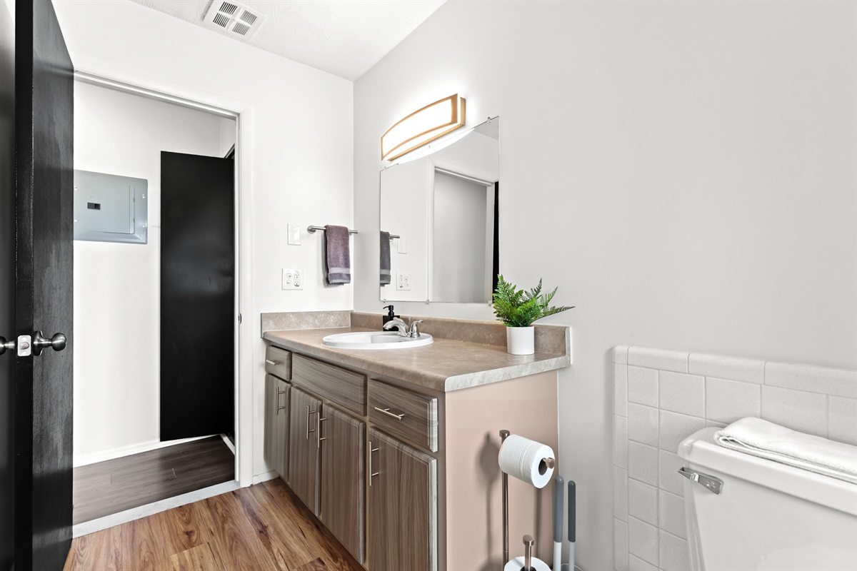 Enjoy a clean and modern bathroom complete with white tile accents, granite countertops, and a full-size tub and shower.