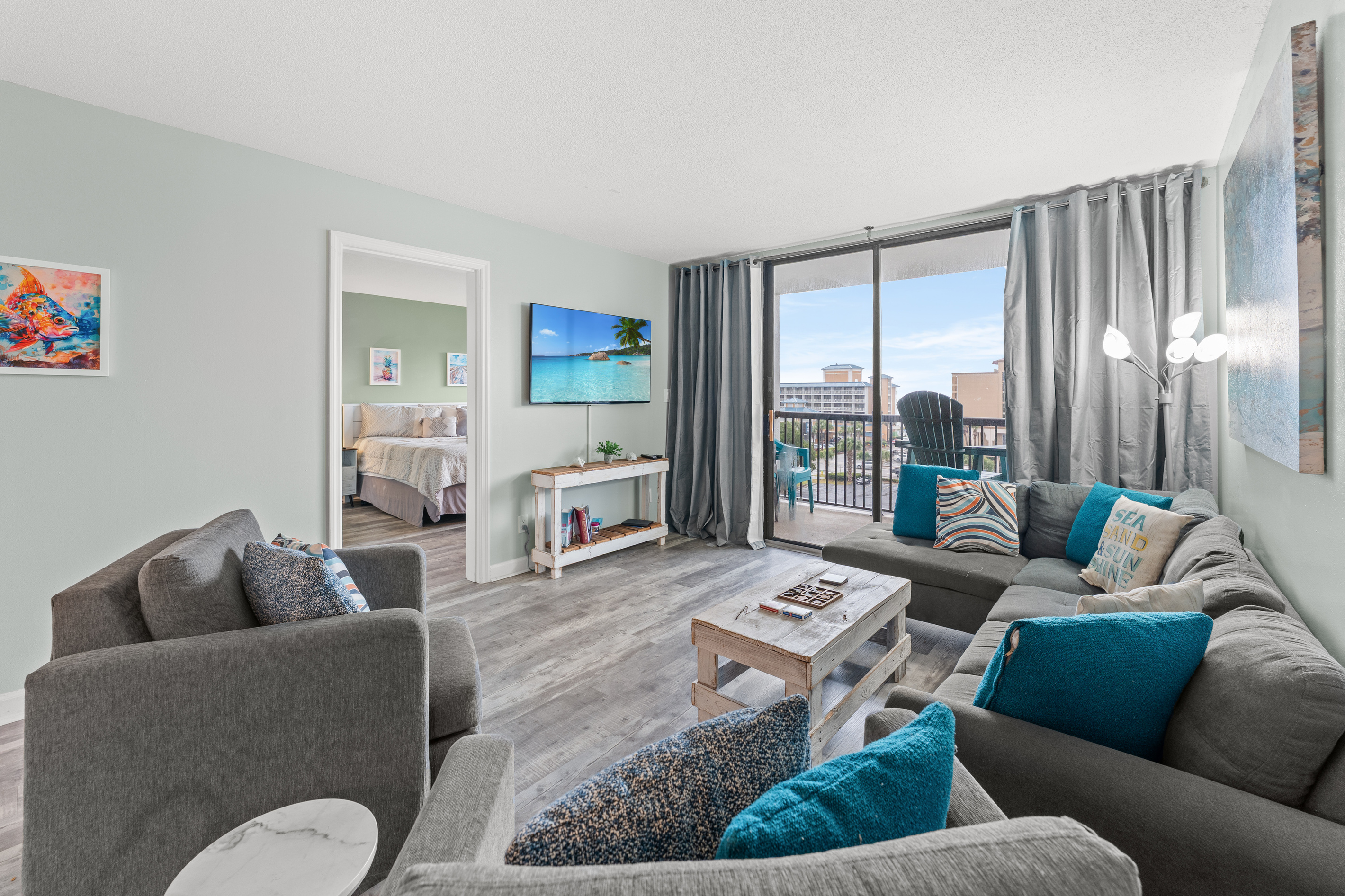 Comfy living room area with large TV and balcony access