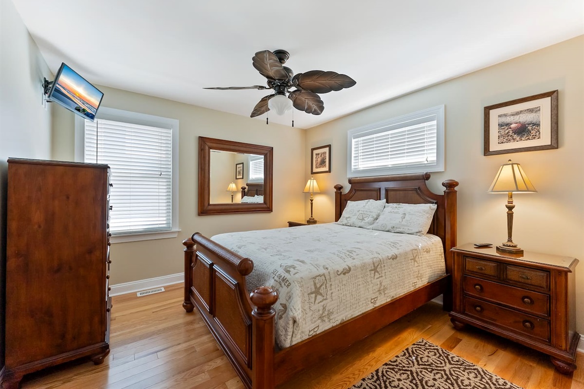 Queen Size Bed with storage, and TV and ceiling fan.  