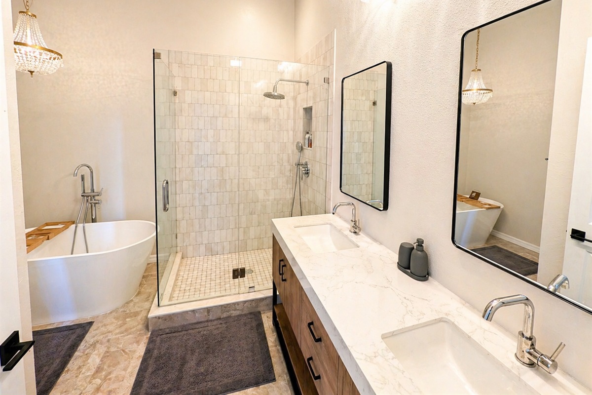 Relax and unwind in this spa-inspired bathroom featuring a deep soaking tub, elegant chandelier lighting, and calming modern décor designed for a luxurious retreat experience.