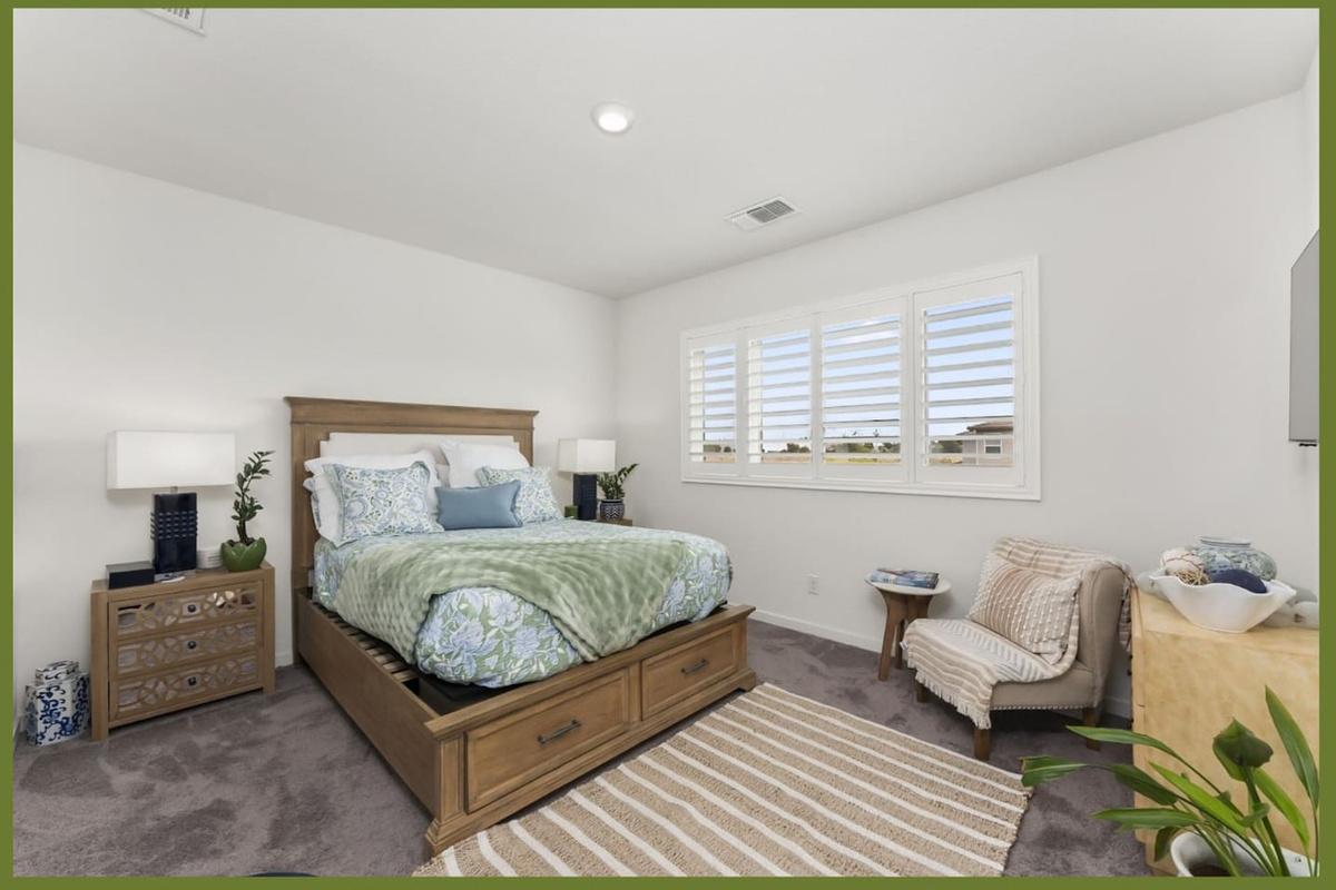 Bedroom with queen bed, dresser storage, accent chair, and bright window light for a comfortable stay.