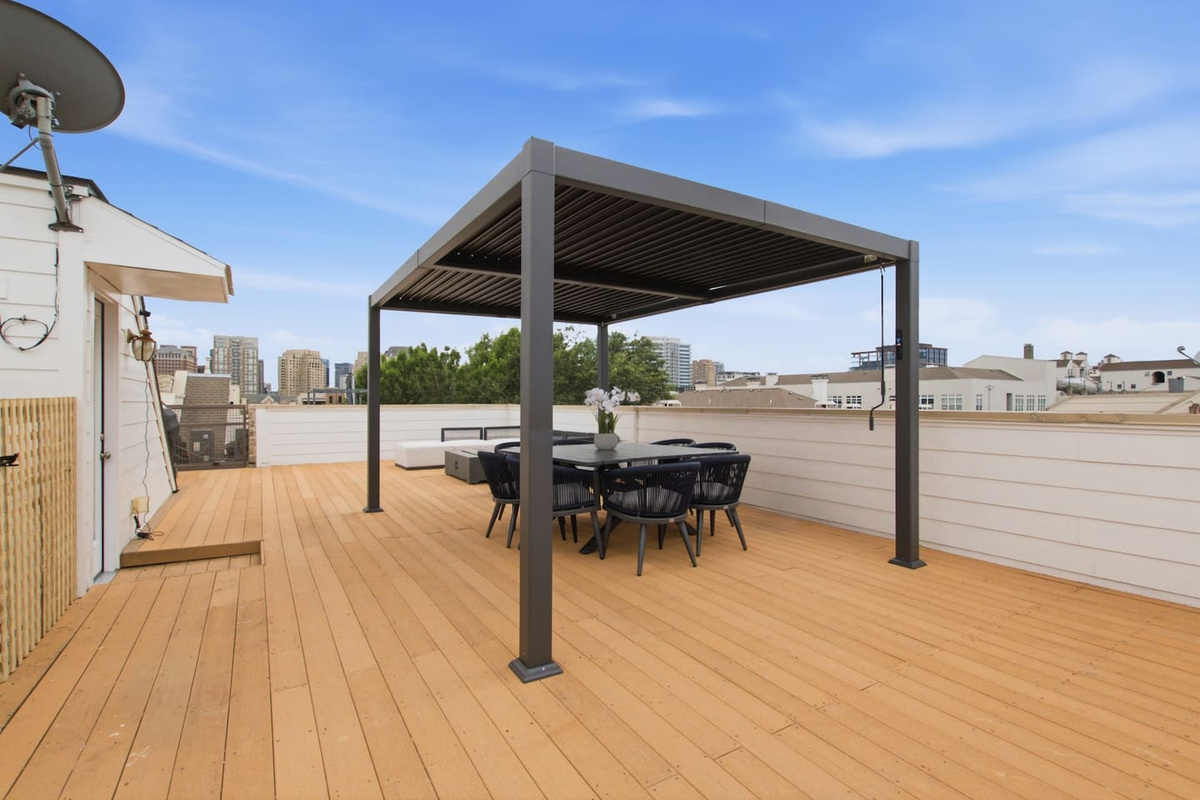 Rooftop deck with pergola, dining table, and unobstructed Dallas skyline views. One of the best private outdoor spaces in this part of the city, right above your front door.

