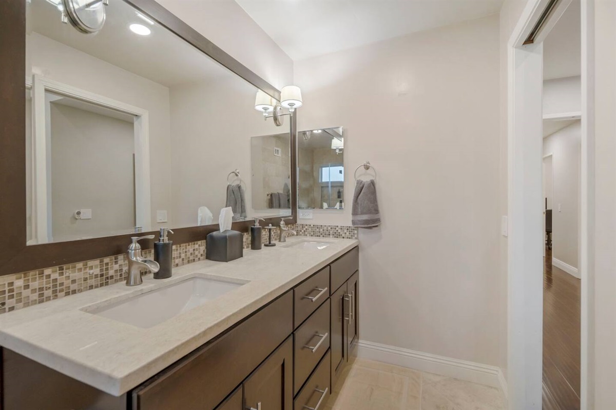 Each person can comfortably use their own sink and countertop space for personal items. The expansive mirror allows both to get ready simultaneously, enhancing efficiency and convenience in the morning routine. 