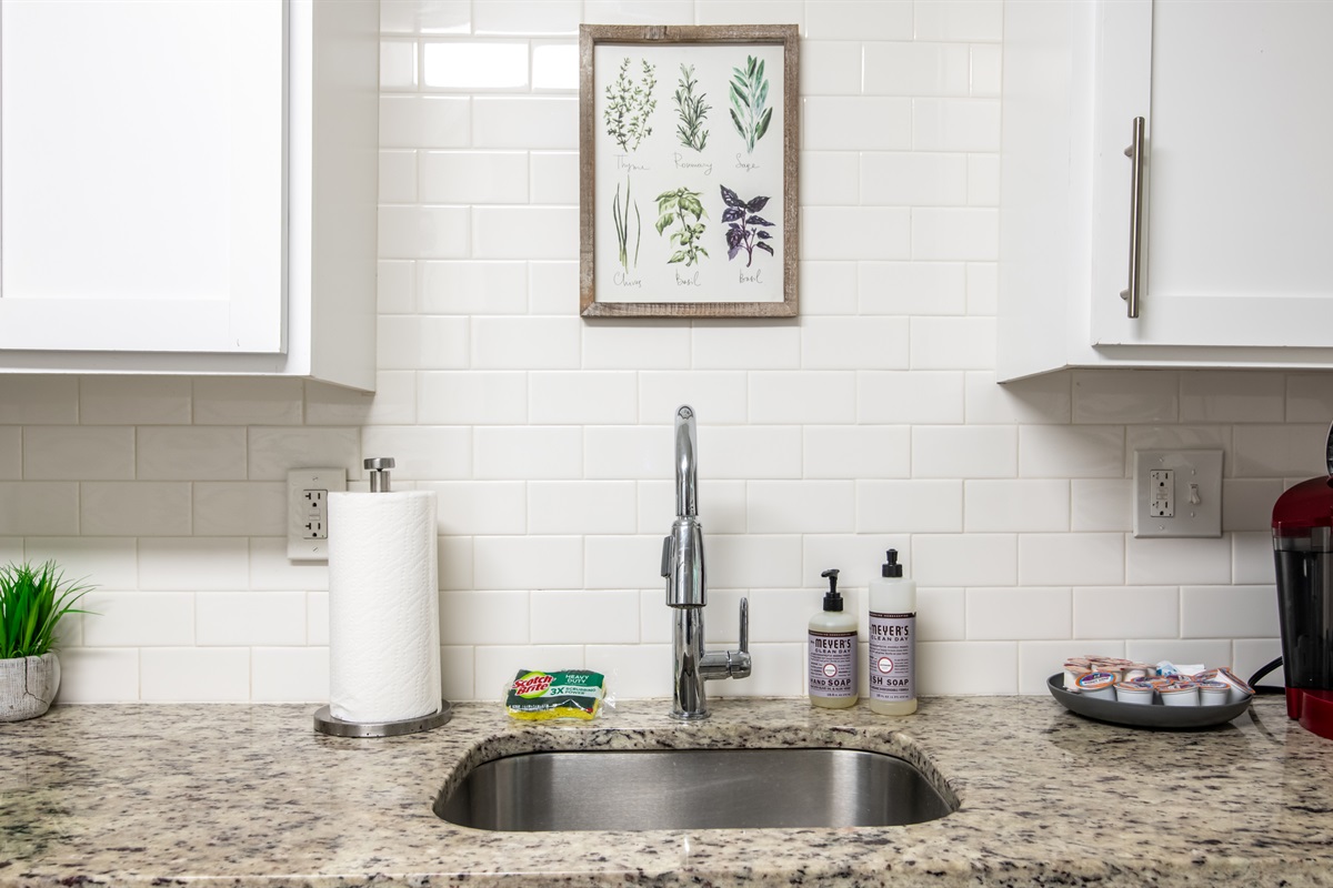 Bright kitchen counter space with stylish white tile backsplash and practical essentials.