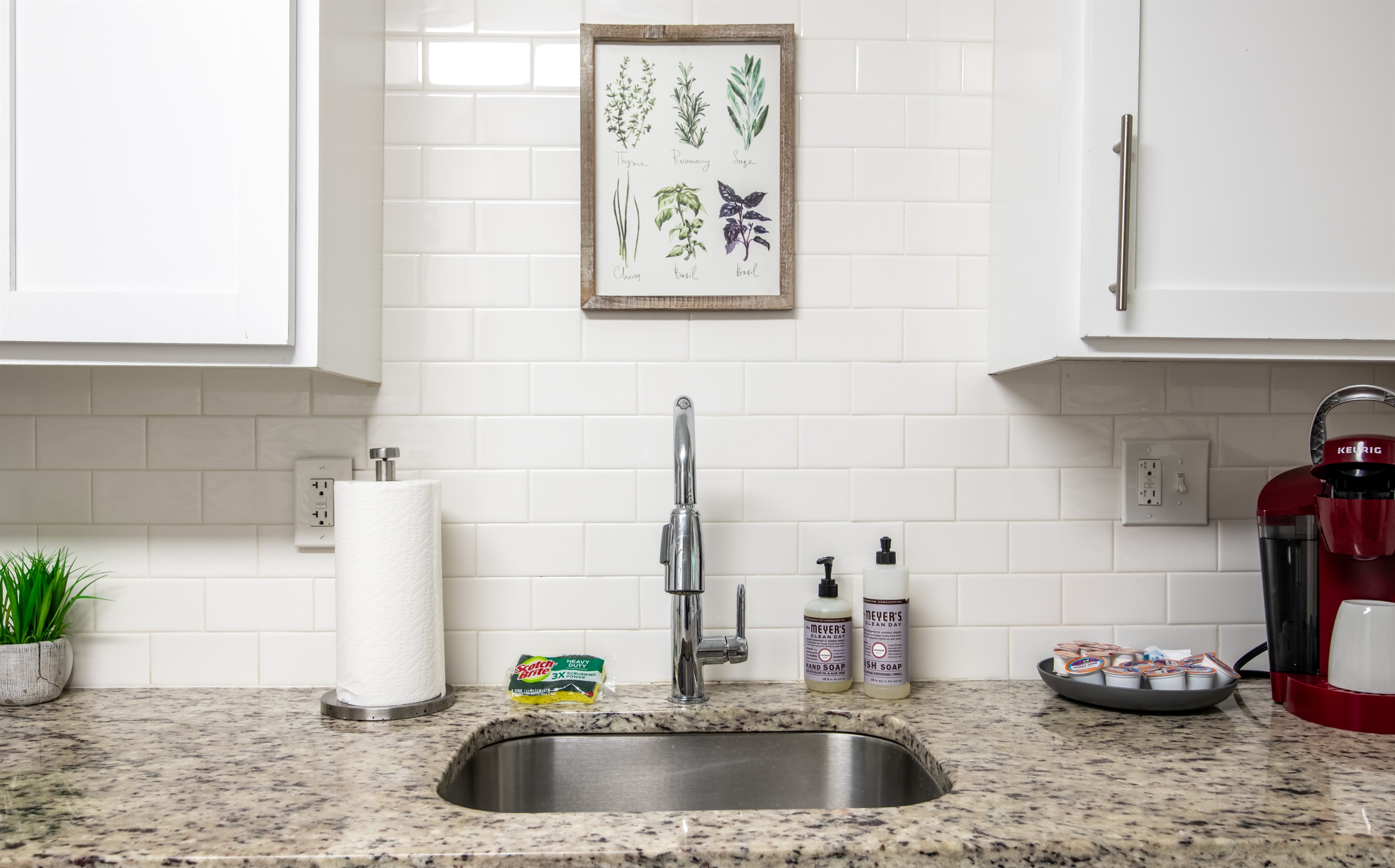 Bright kitchen counter space with stylish white tile backsplash and practical essentials.