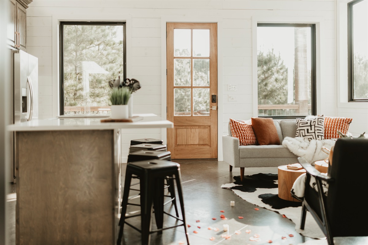 Warm light, forest views, and soft petals scattered across the floor—this romantic open-concept space is ready to set the mood.