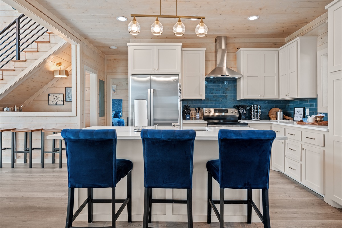 Bright kitchen with large island seating, stainless appliances, and stylish finishes.