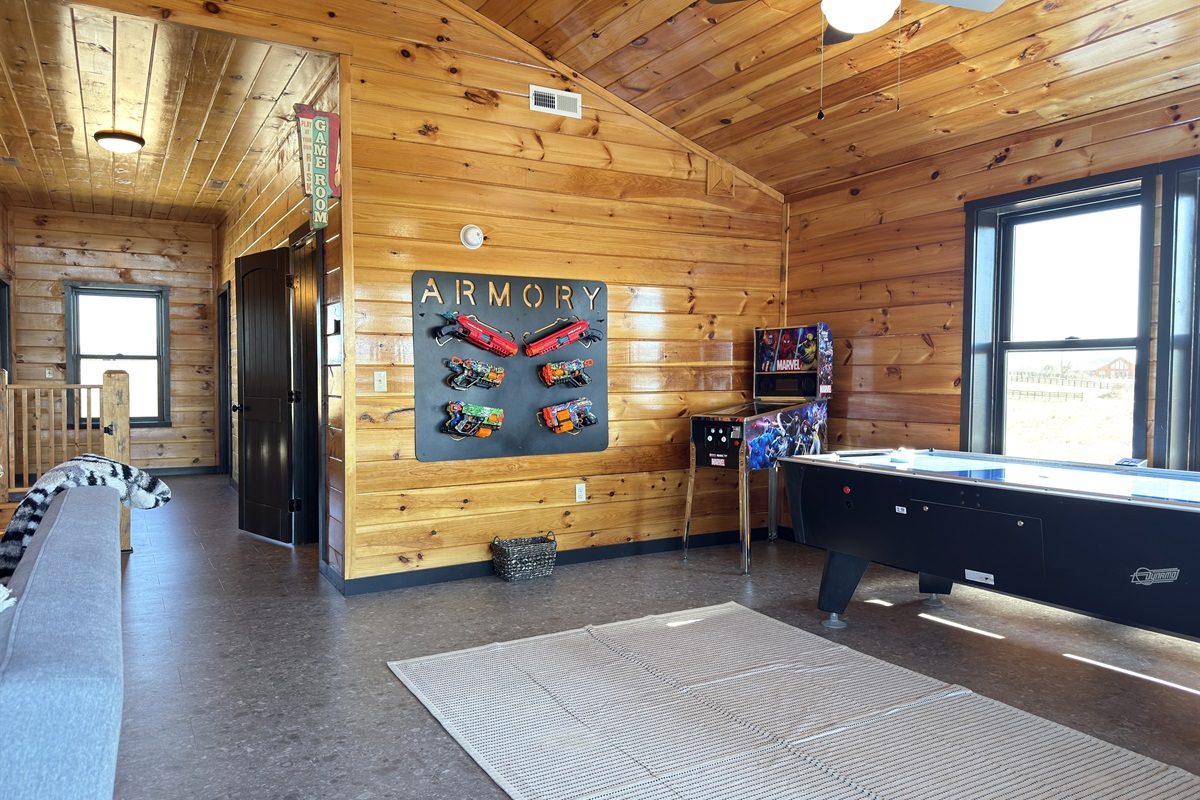 Upstairs game room with nerf blaster, air hockey, & retro arcades.