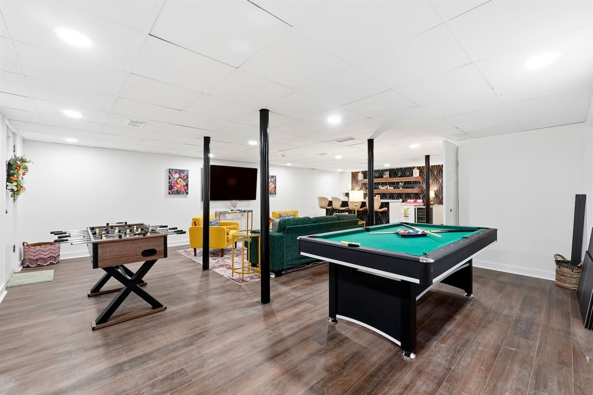 Amazing game room located in the basement, featuring a pool table, foosball table, and a stylish bar perfect for entertaining and relaxing with friends and family.