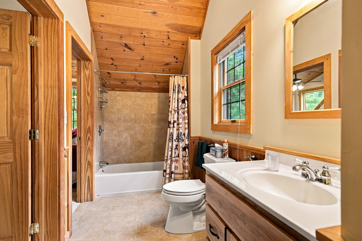 The bright bathroom offers a spacious vanity and tub-and-shower combination.