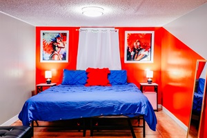 Serene Escape: King-size Bed in Tranquil Blue, Against a Cheerful Backdrop of Orange and White Walls, Under a Crisp White Ceiling 🛏️🧡💙