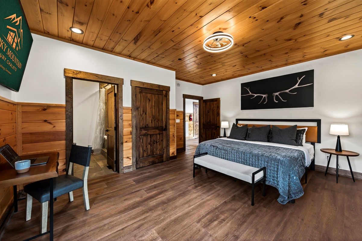 Relax in the spacious king bedroom with a large TV, dedicated desk workspace & direct deck access. Unwind in the en-suite bathroom featuring a walk-in shower with a natural river rock floor, bringing  the Smoky Mountains indoors for a spa retreat.
