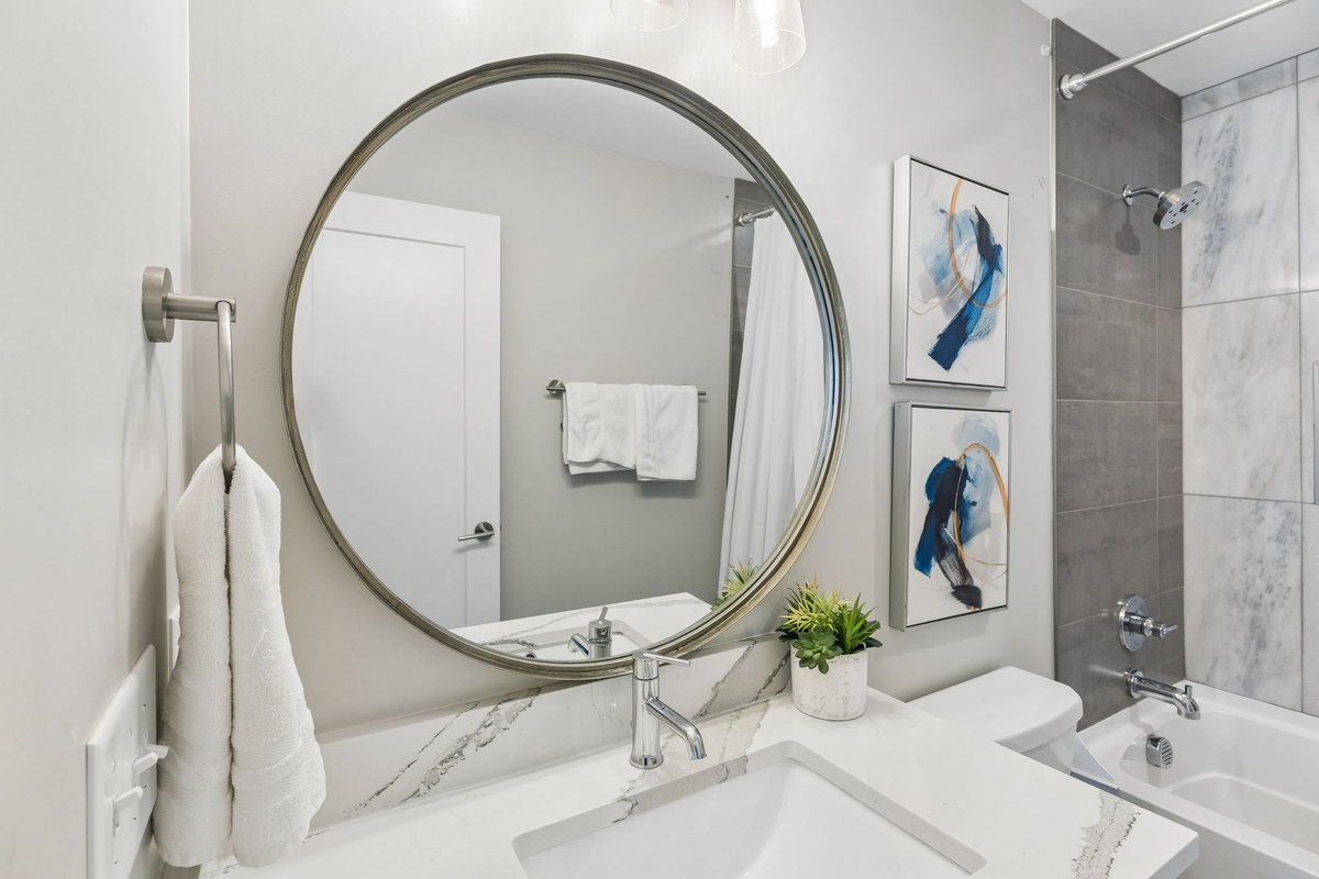 Step into the third full bathroom and you'll get the same clean finish as the rest of the house &mdash; tub-shower combo, white tile, ready for your group.