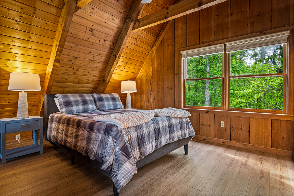 Upper level bedroom, with view of the woods.