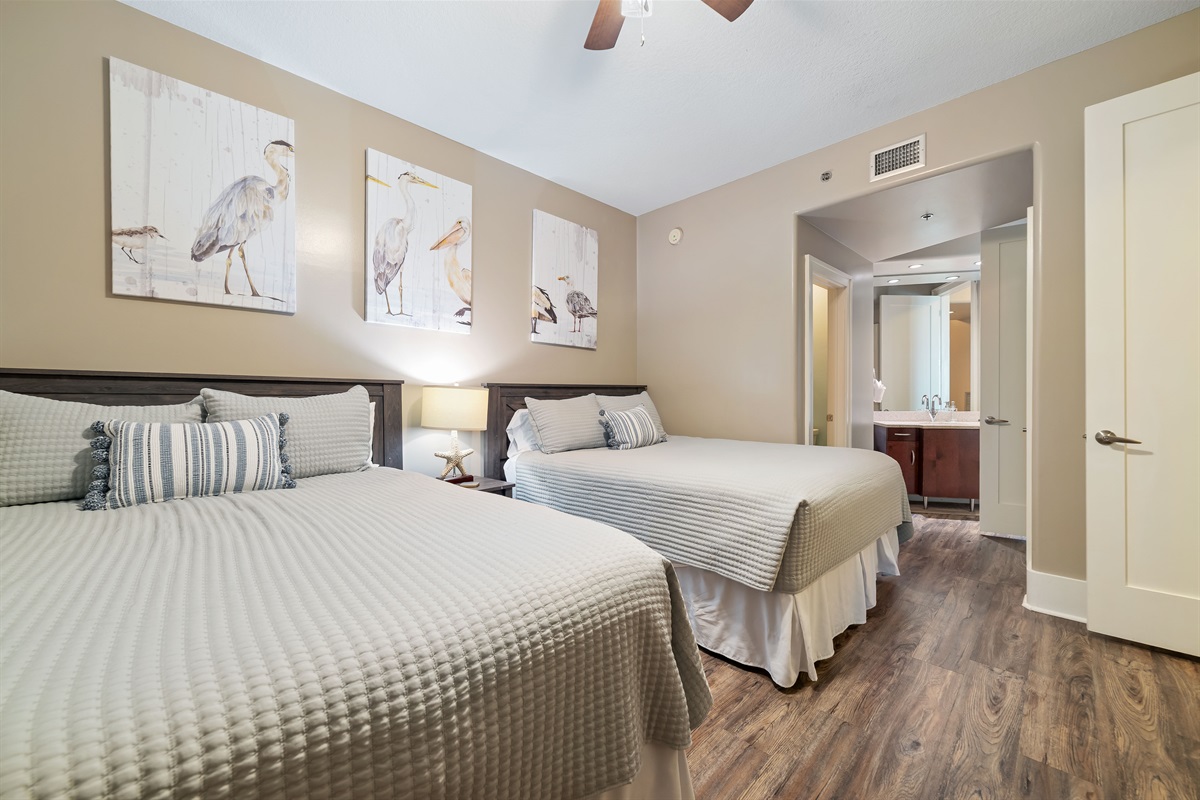 A charming bedroom featuring two comfortable Queen beds, perfect for sharing and relaxation after a day of coastal adventures.