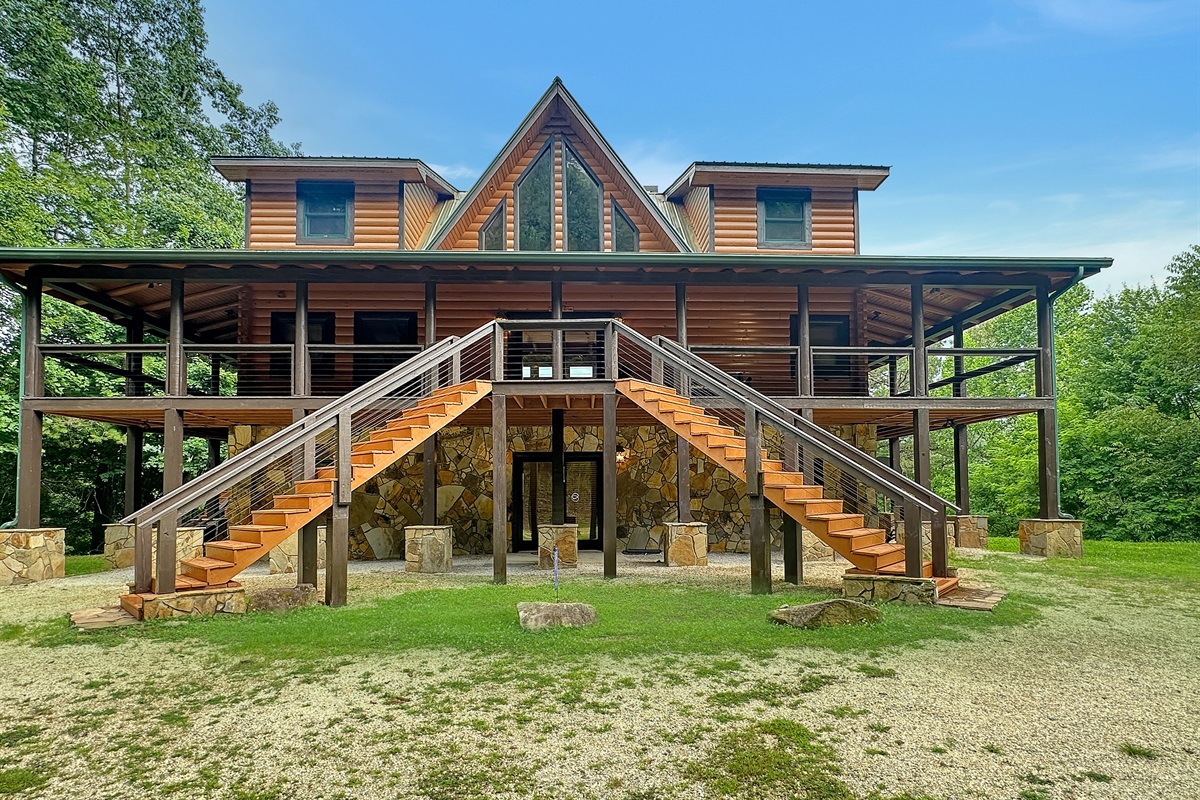 Exterior: Stunning mountain retreat with vibrant stone accents and inviting wraparound porch!