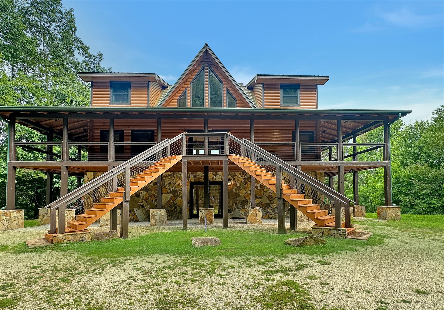 Exterior: Stunning mountain retreat with vibrant stone accents and inviting wraparound porch!