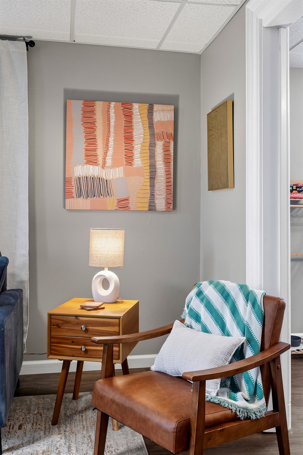 Mid-century accent chair and curated wall art give the space a boutique feel