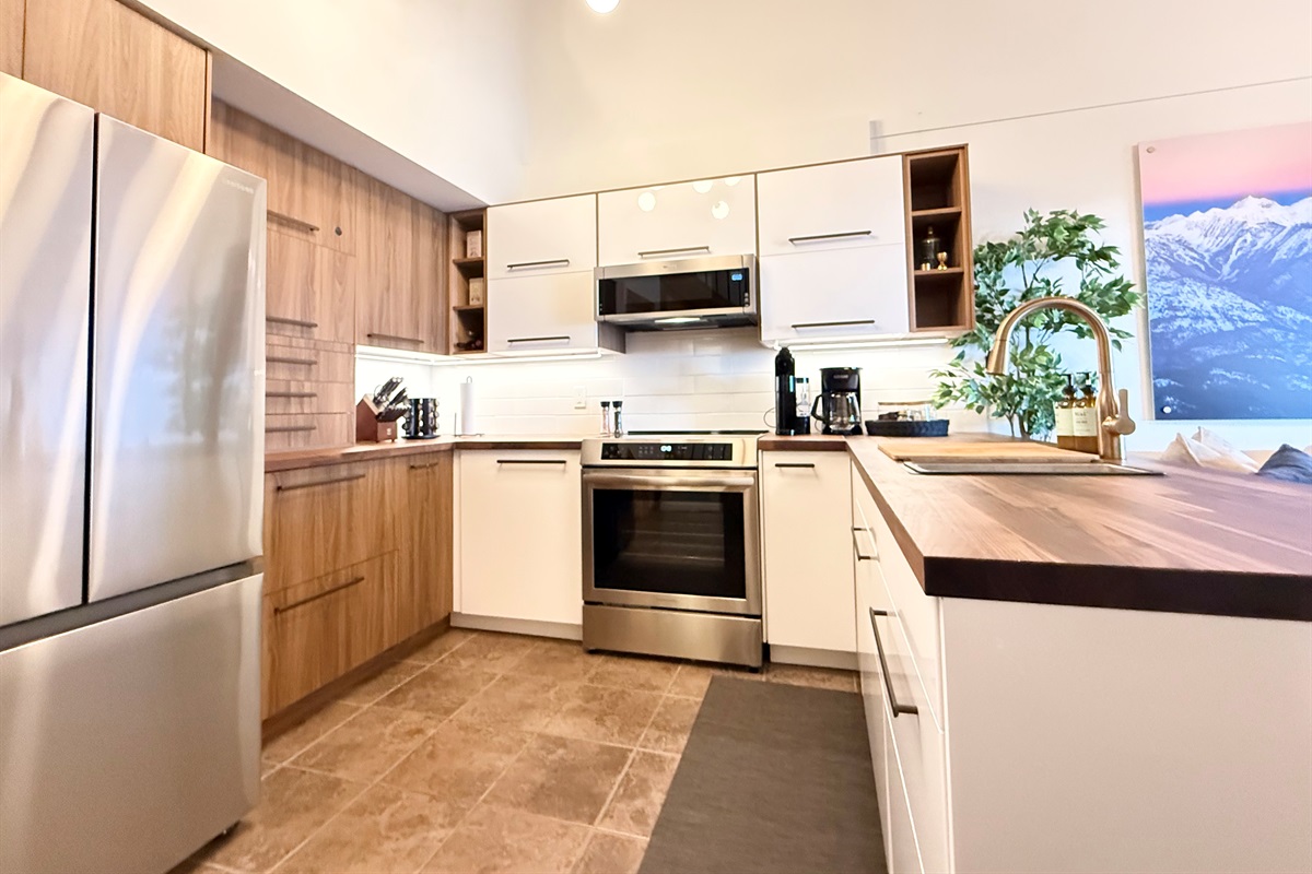 Fully Equipped Kitchen: Prepare delicious meals in this modern kitchen at your Kimberley rental, featuring a full-size french door fridge, induction range, and ample cabinet space for all your cooking needs.