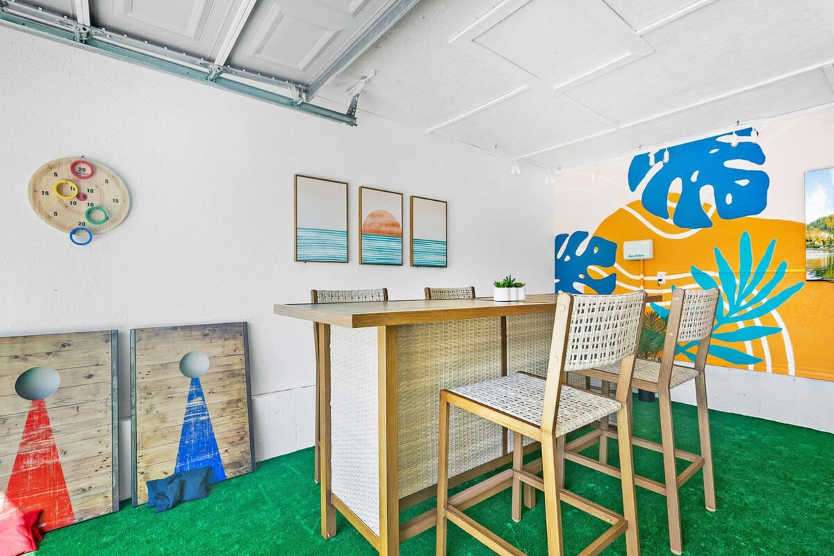 Bar stools pulled up at the counter, boards and games propped against the wall, and that mural doing all the heavy lifting. It is genuinely hard to be in a bad mood in a room painted quite this cheerfully.