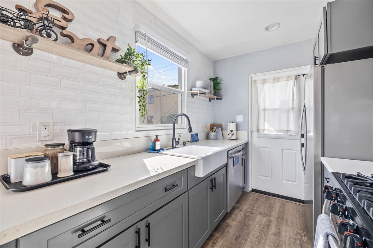 Upgrade your culinary experience with a stylish sink, sleek faucet, and decorative hand soap dispenser. This modern, functional setup enhances the kitchen's aesthetic, creating a clean, inviting space for meal prep and cooking during your stay!