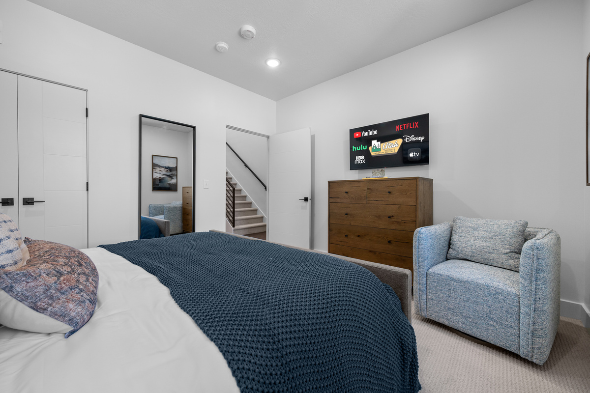 Spacious primary bedroom with Smart TV and cozy seating area.
