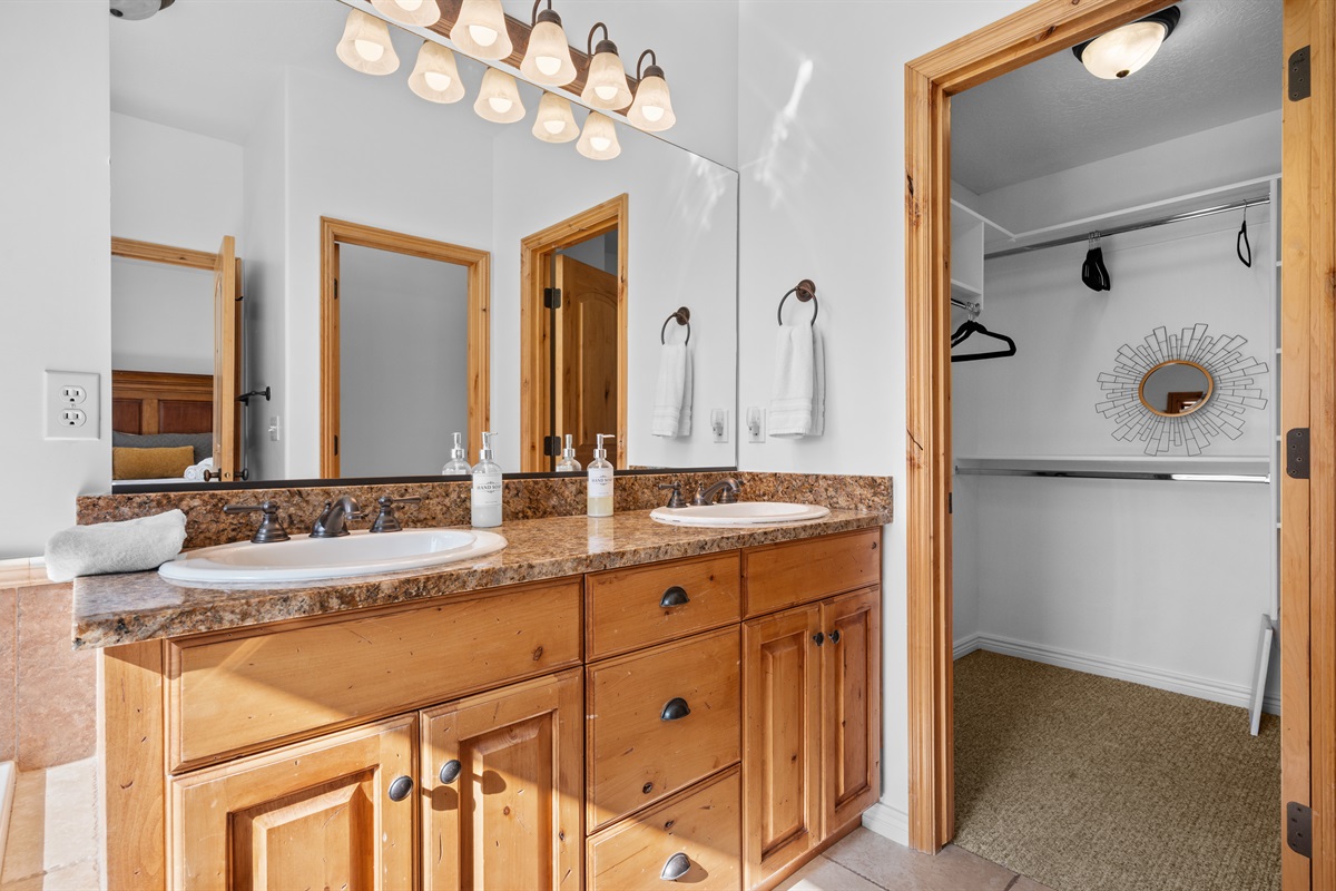 Enjoy dual sinks, warm wood cabinetry, and a convenient walk-in closet just steps away.