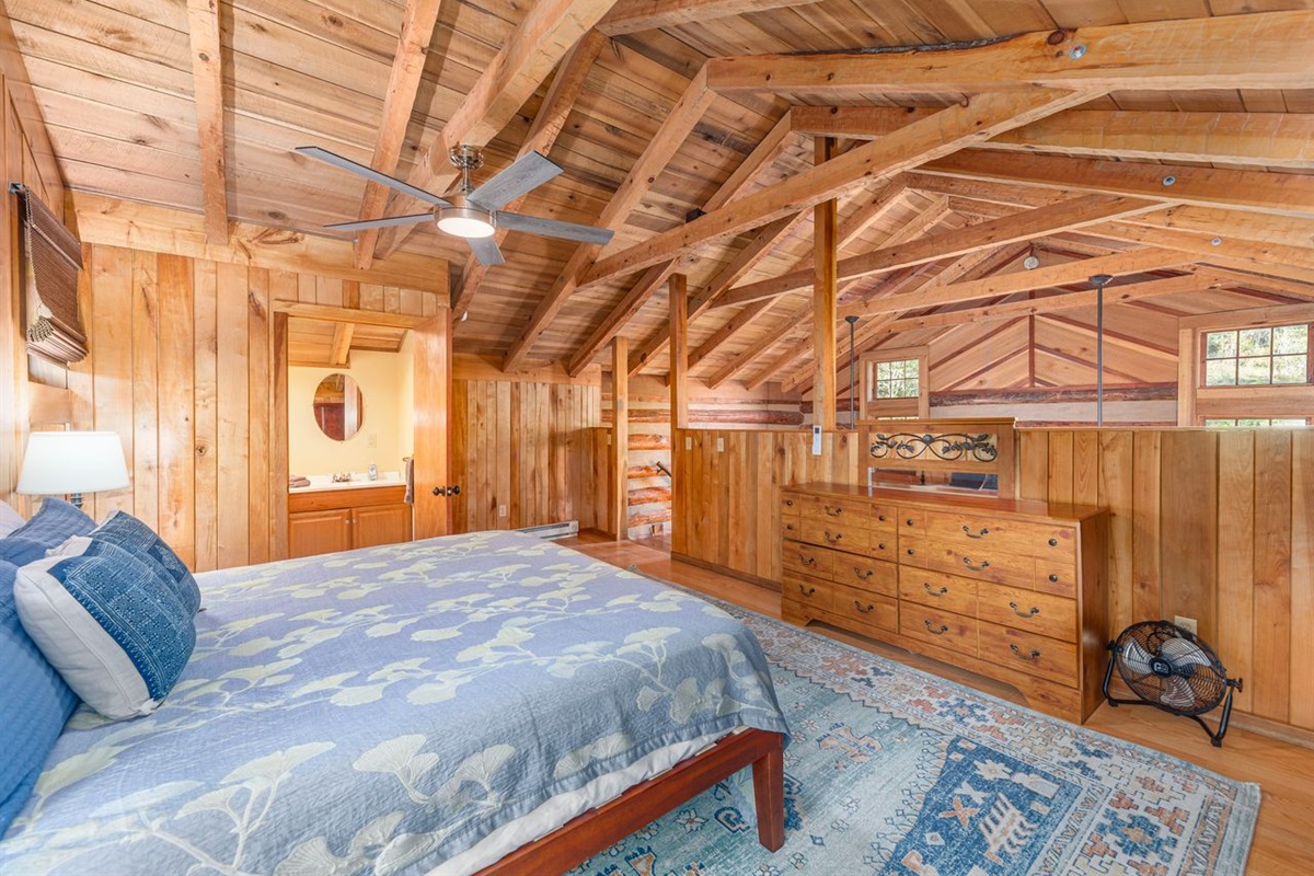 With exposed wood beams, the loft bedroom features a king size bed.