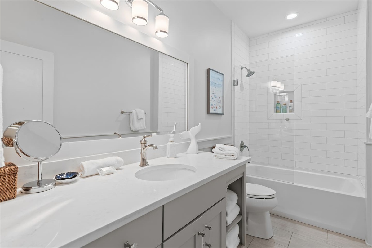 Bunk room bathroom with large vanity, tiled shower and tub