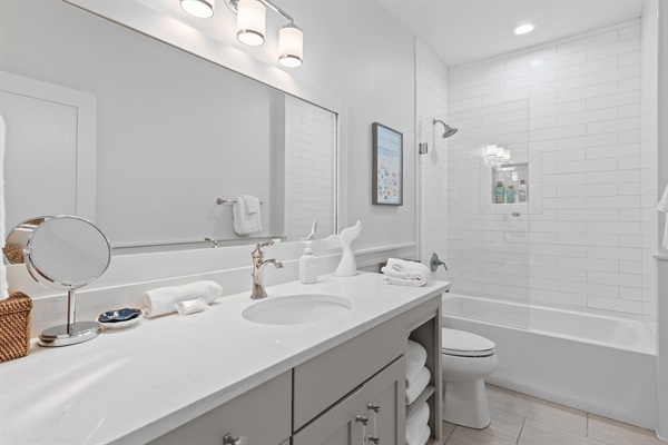 Bunk room bathroom with large vanity, tiled shower and tub