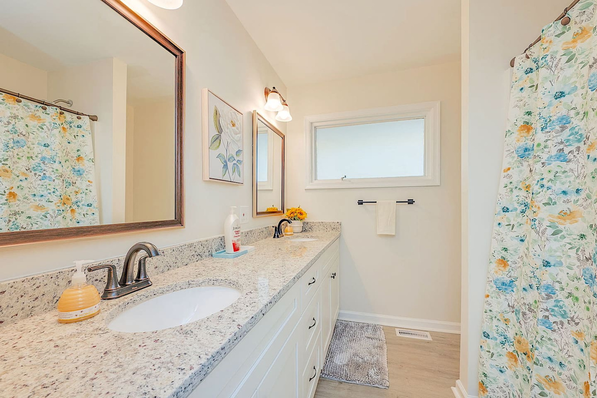 Bathroom #1 with a double vanity and bath / shower combo.