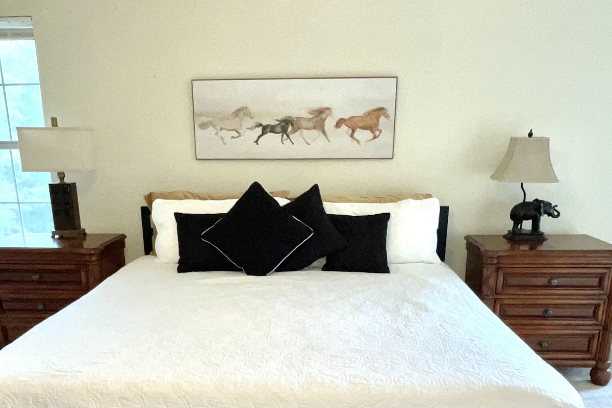 Spacious Master Suite Features King Sleeping, Memory Foam Mattress Topper, Bedside Charging Stations,  40-Inch LED Smart TV, and a Cozy Reading Nook/Office Space.