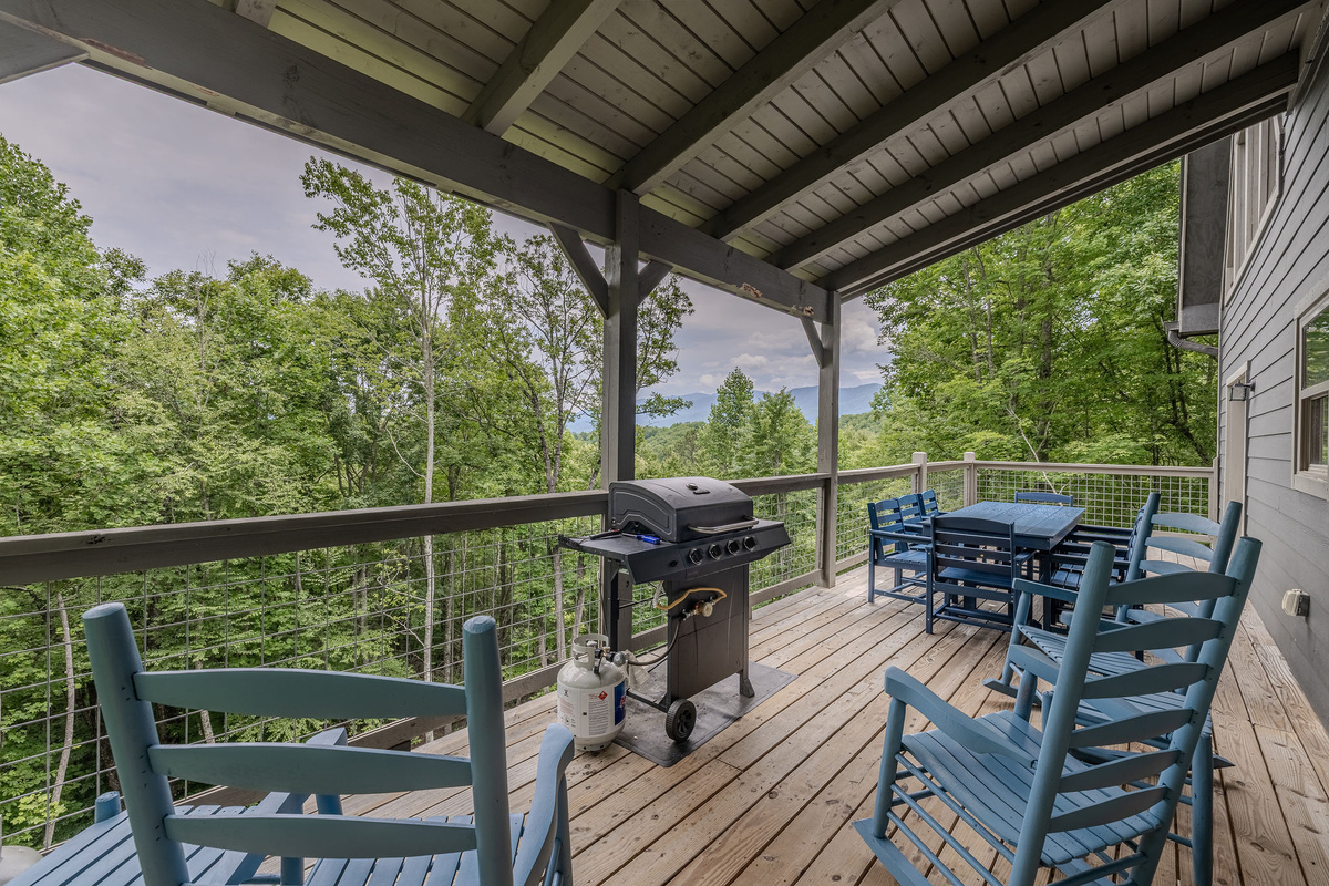 Enjoy fresh mountain air and wooded views from the covered deck.