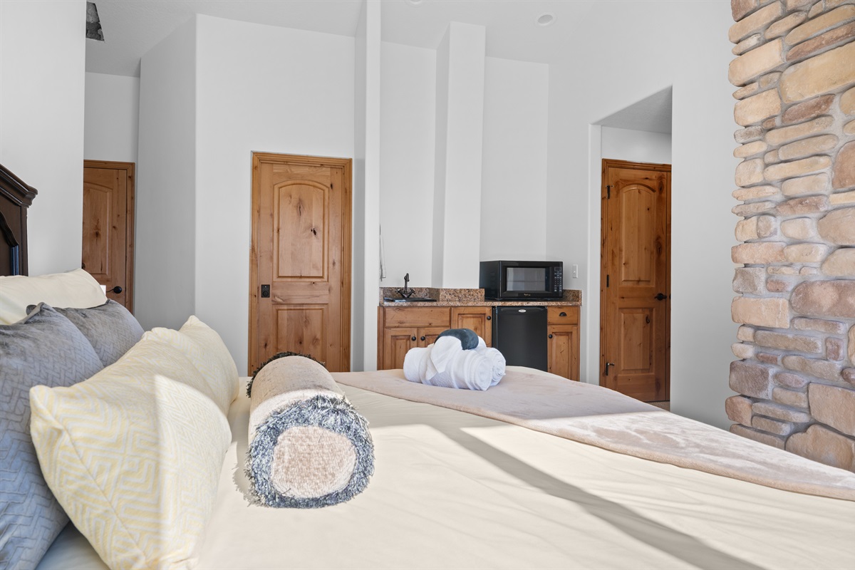 Retreat to this private bedroom with a fireplace ambiance and kitchenette.itchenette with microwave and sink, ideal for added convenience and comfort.