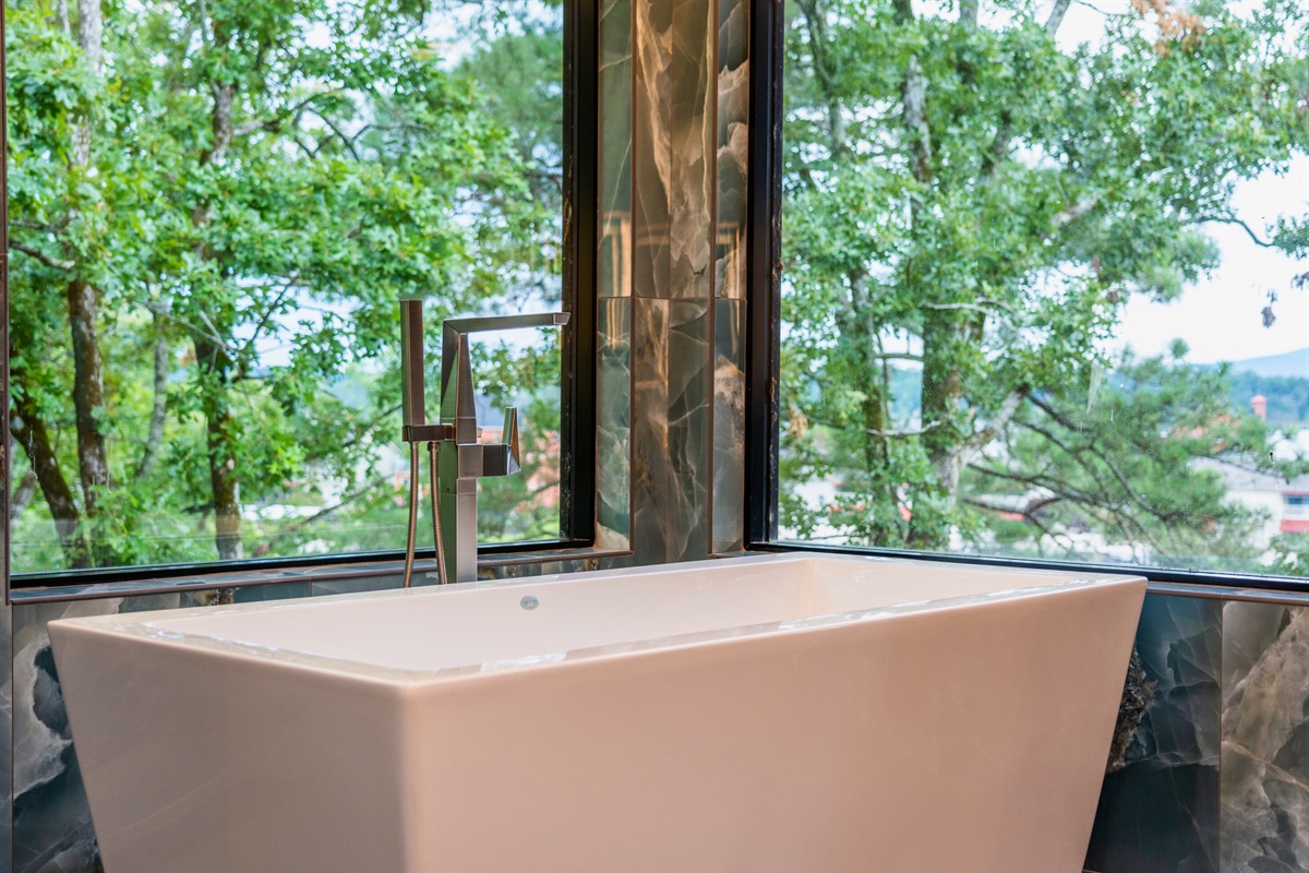 Who wouldn't want to unwind in this beautifully designed, light-filled bathroom? The sophisticated tilework and spacious tub create a perfect retreat.