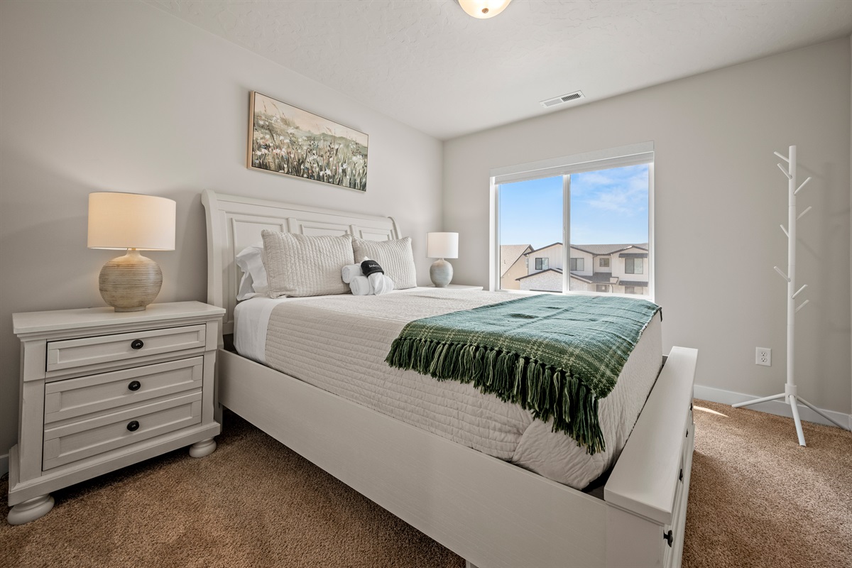 Relax in comfort with a storage platform bed, warm lighting, and a large window that fills the room with natural light.