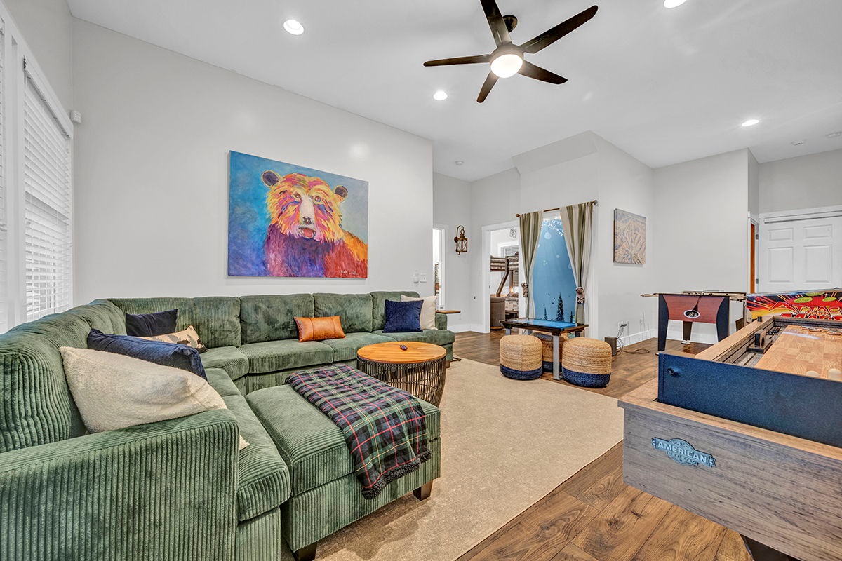 Downstairs game room with cozy large sofa, infinity game, fooseball and suffleboard tables, pinball machine and a cozy nook for the little ones.