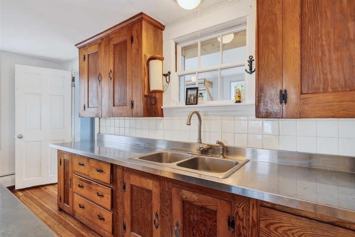 Original kitchen cabinetry and stainless-steel countertop (no dishwasher)