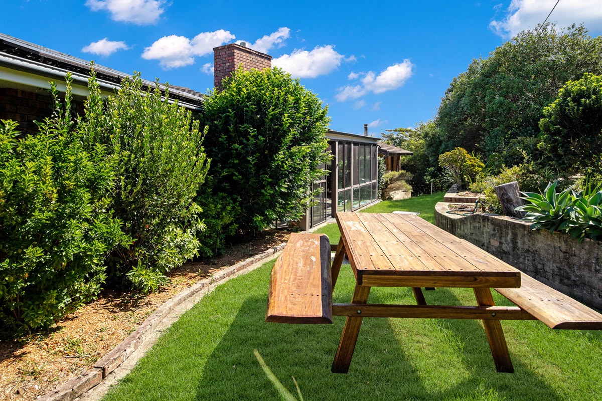 A private garden setting gives this outdoor dining area a relaxed beach-house feel, with greenery wrapped around the yard at Bertie’s 3 Beaches.