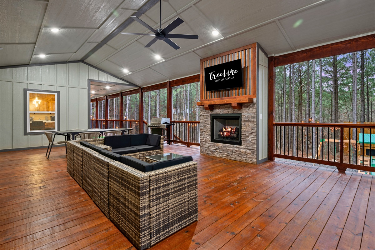 The outdoor living area features comfortable seating and a fireplace, creating a cozy place to gather in the evenings while enjoying the fresh mountain air.