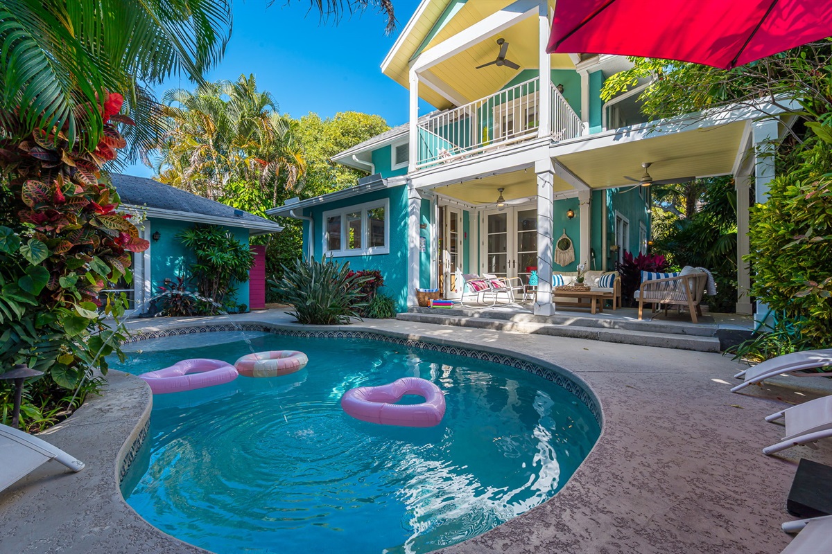 Step into your private tropical oasis featuring a heated pool, sun loungers, an outdoor shower, and a romantic string-lit cabana. Enjoy relaxing or entertaining under the covered patio with comfortable seating and dining, and magnificent pool views.