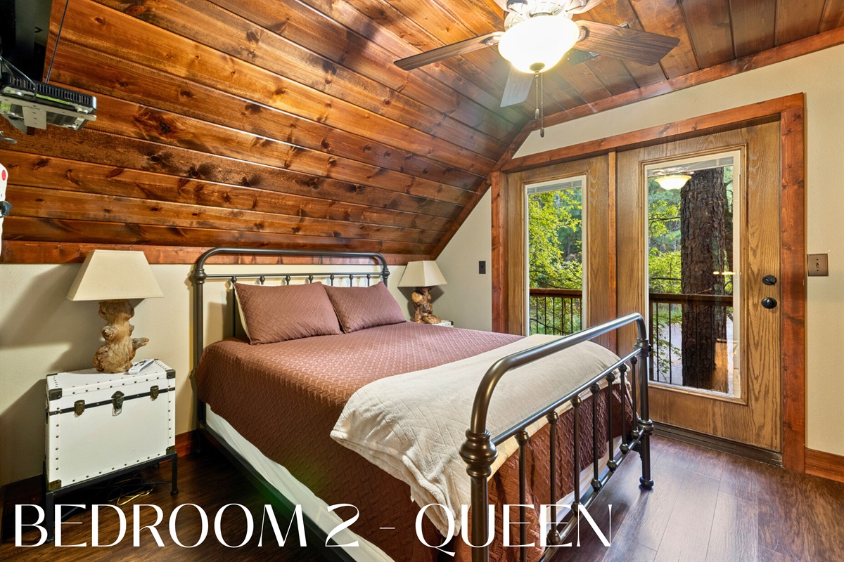 Bedroom 2: queen bed with wooded views and cabin comfort.