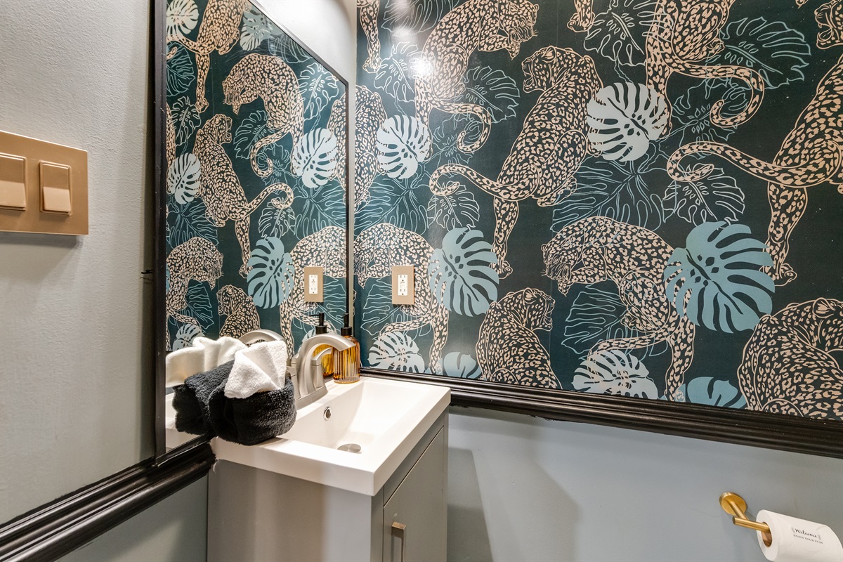 Main Floor Full Bathroom: Bold leopard wallpaper and chic decor create a vibrant retreat for guests!
