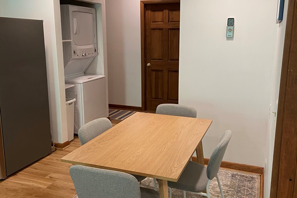 Dining area with view of the laundry space. The bathroom is down the short hall to the left.