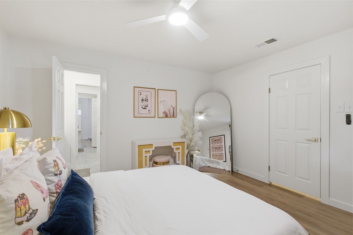 Bedroom 3 wide-angle showing hardwood floors, arched mirror, and full layout. Room-darkening shades and lock on bedroom door included.