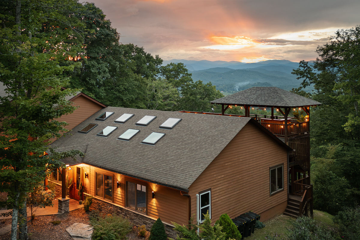 {Private Mountain Resort} Expansive decks wrap the mountainside home, creating multiple places to gather outside while surrounded by the forest.