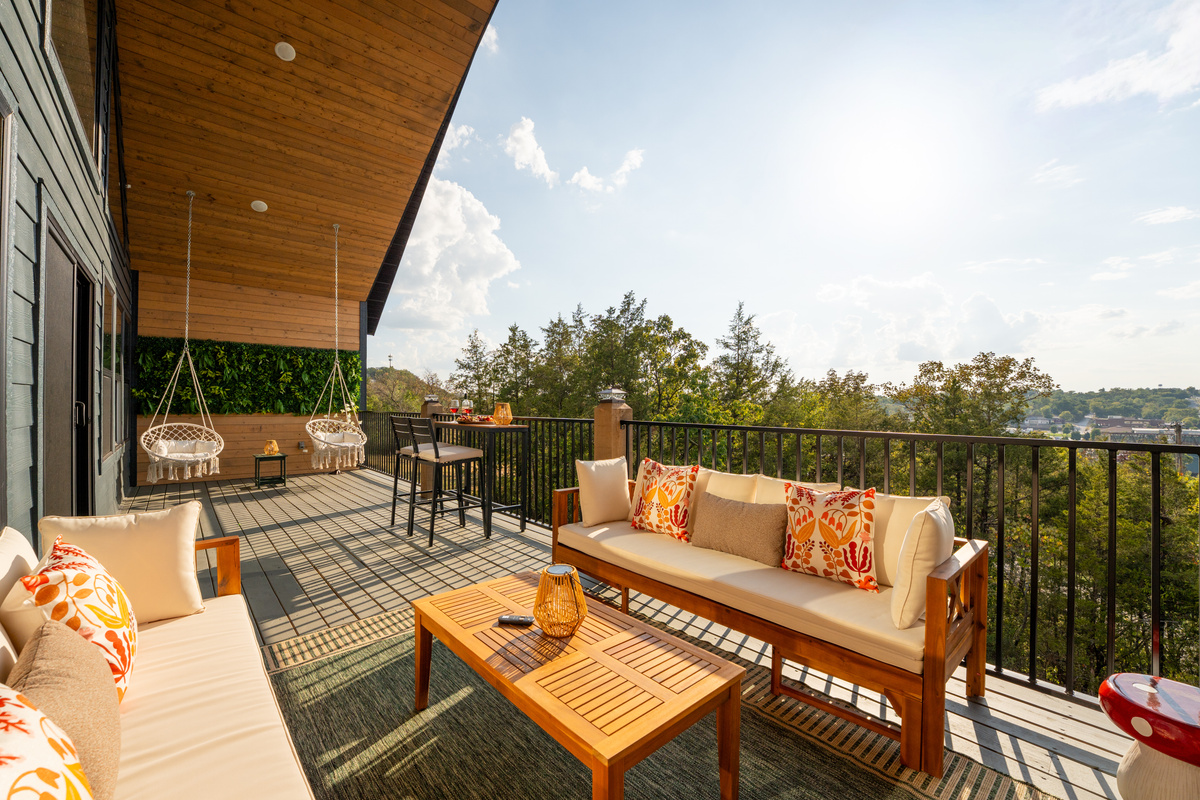Relax on the covered deck with comfortable seating and beautiful views beyond the railing.