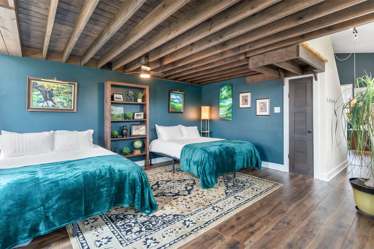 Historic beams, rich color and original artwork make this anything but an ordinary bedroom.