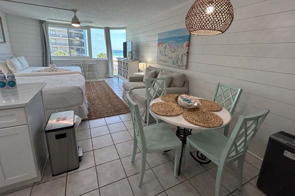 Bright, open-concept beachfront studio featuring a fully equipped kitchen, dining area, comfortable living space, two queen beds, and beautiful Gulf views.